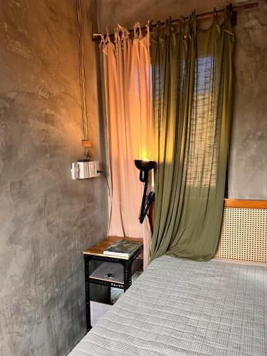 a bedroom with a bed and a table with a window at Mơ House Eco Homestay on hill in Phú Quốc