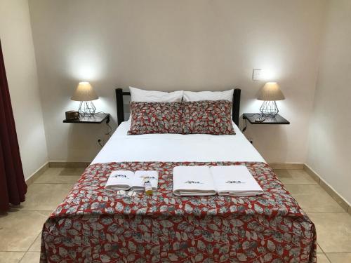 a bedroom with a bed with two books and two lamps at Casa Penélope in Puerto Ángel
