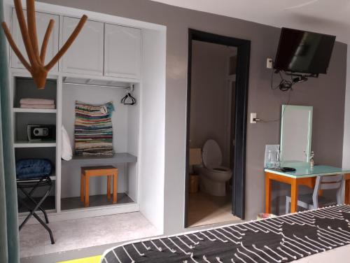 a bedroom with a bed and a bathroom with a toilet at Un Sueño Valle de Huajes in Oaxaca City