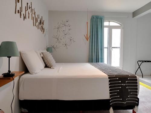 a bedroom with a large white bed with a window at Un Sueño Valle de Huajes in Oaxaca City