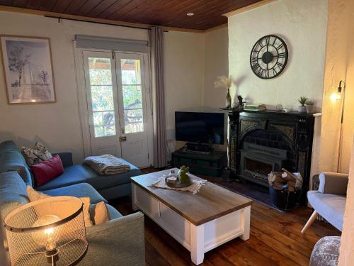 a living room with a couch and a fireplace at Gladstone House in Beechworth