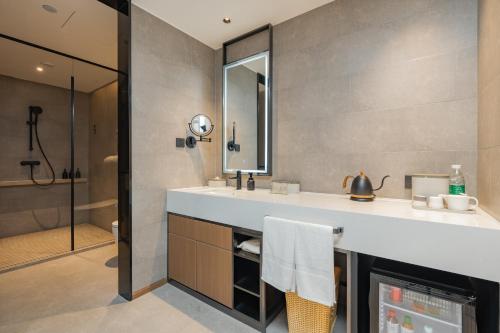 a bathroom with a sink and a shower at Atour Hotel Jiading Nanxiang in Jiading