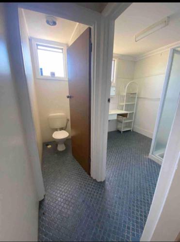 a bathroom with a toilet and a window at Central on Smith in Kalbarri