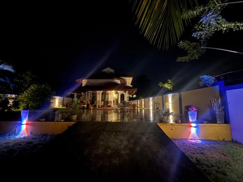 a house lit up at night with lights at Villa Sama Mandira in Ranna