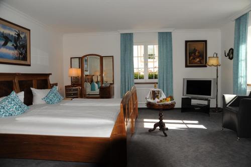 a bedroom with a large bed and a living room at Hotel Adler - Weil am Rhein in Weil am Rhein