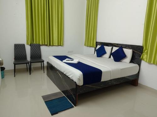 Un dormitorio con una cama con dos sillas y cortinas verdes. en Luxury Villa Rooms Phamacity Genome Valley, en Turkapally