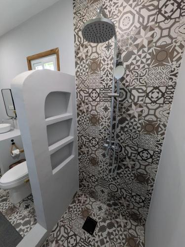 a bathroom with a shower and a toilet at Cozy Shell in General Luna