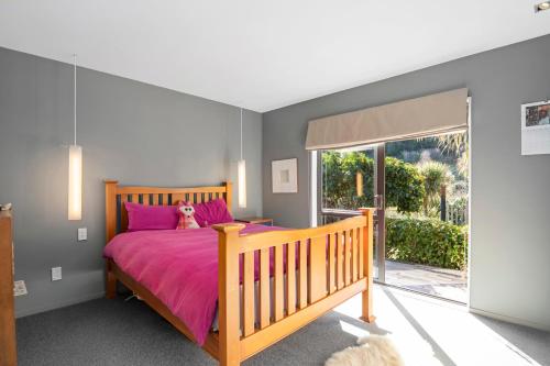 En eller flere senge i et værelse på Brook Beauty - Nelson Holiday Home