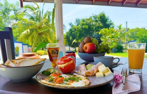 a table with a plate of food and some drinks at Villa Sama Mandira in Ranna