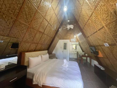 a bedroom with a bed in a room with a ceiling at Casa Gracia's Hotel and Restaurant in San Aquilino