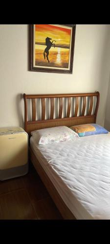 a bedroom with a bed and a painting on the wall at Maitinga, a little paradise in Bertioga