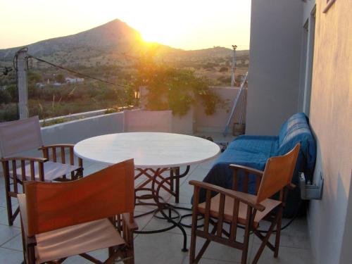 a balcony with two tables and chairs and the sunset at Sunset at Cape Sounio in Sounio