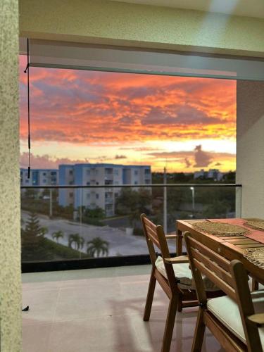een balkon met een tafel en stoelen en uitzicht op de zonsondergang bij Palmera 402 in Punta Cana