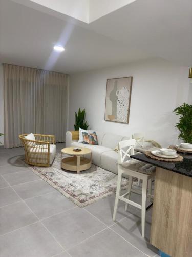 een woonkamer met een bank en een tafel bij Palmera 402 in Punta Cana