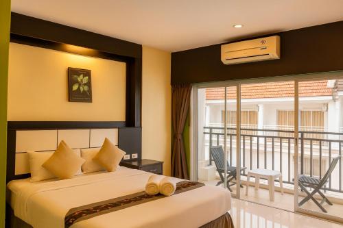 a bedroom with two beds and a balcony at Star House Patong in Patong Beach