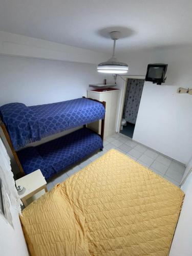a room with a blue bed and a yellow rug at Los Manantiales in Villa Gesell