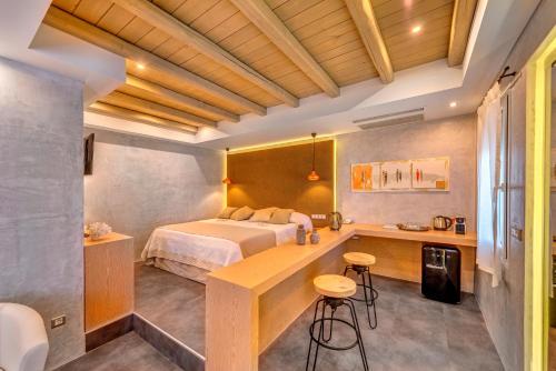 a room with a bed, a desk and a chair at Nissaki Beach Hotel in Naxos Chora
