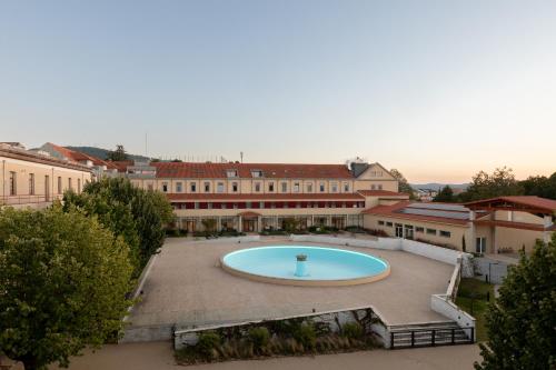 uma grande piscina em um pátio dentro de um edifício em Stella Braga Aparthotel em Braga