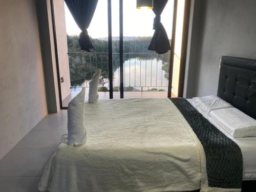 a bedroom with a large bed with a large window at Nakawe Guatape in Guatapé