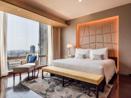 a bedroom with a large bed and a large window at VIE Hotel Bangkok - MGallery Collection in Bangkok