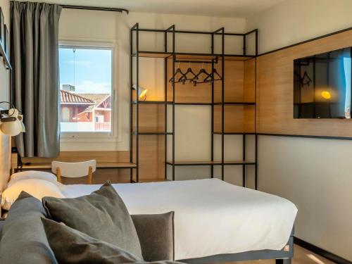 1 dormitorio con litera y sofá en ibis Ciboure Saint-Jean-de-Luz, en Ciboure
