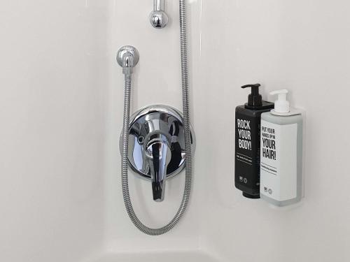 cabezal de ducha con manguera pegada a la pared en ibis Ciboure Saint-Jean-de-Luz, en Ciboure