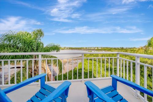 a balcony with blue chairs and a view of the ocean at 6B Waterfront Game Room Pool Hot Tub Dock in Palm Harbor