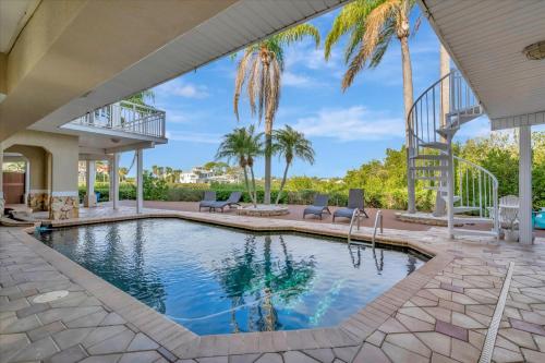 a swimming pool in a house with palm trees at 6B Waterfront Game Room Pool Hot Tub Dock in Palm Harbor