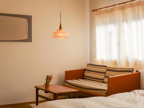 a bedroom with a chair and a table and a lamp at horn ホルン in Kofu