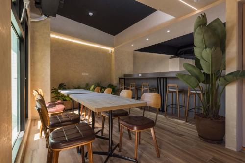 una sala da pranzo con tavolo, sedie e una pianta di SUPERB HoTEL a Magong