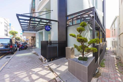 un bonsai su un marciapiede accanto a un edificio di SUPERB HoTEL a Magong