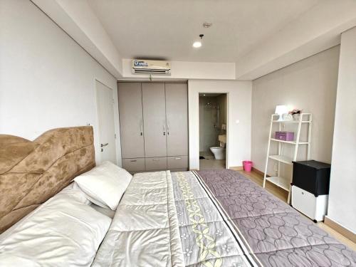 a bedroom with a large bed in a room at Stylish 3BR Skandinavia Tangcity Apt Max 12 Guests in Karawaci