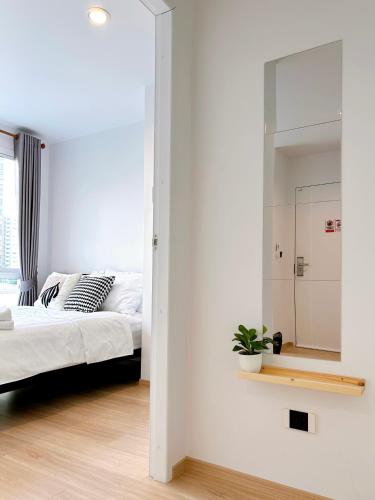 a bedroom with a bed and a mirror at Komfy Quarters in Sathani Bang Khen