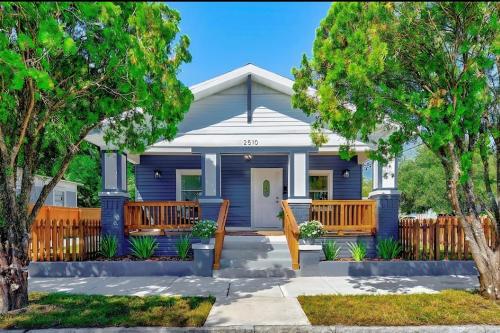 a blue house with two wooden benches in front of it at Casa De Ybor 3Bd, 2Bth, 4 beds, Historic Charm, Modern Lux in Tampa