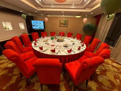 einen Konferenzraum mit einem großen Tisch und roten Stühlen in der Unterkunft Greenland Mansion in Shanghai