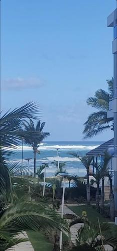 a view of a beach with palm trees and a building at Luxury Cabarete East Condominiums in Cabarete