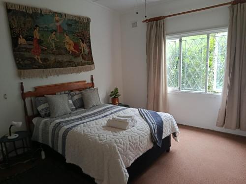 um quarto com uma cama e uma janela em Serendipity-on-Symmonds Cottage em Howick