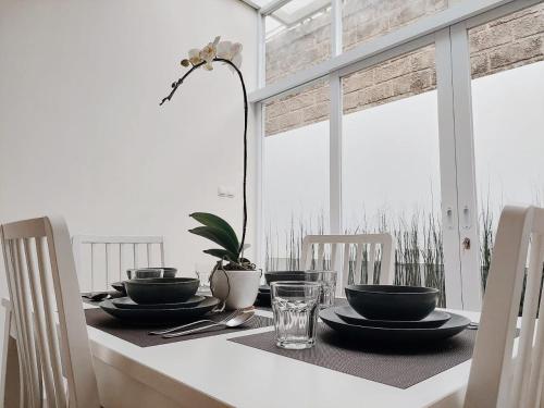 a dining room table with plates and glasses on it at Villa LA Lembang Retreat - Bed & Breakfast in Lembang