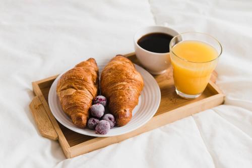 een dienblad met croissants en een glas sinaasappelsap bij eL Hotel & Resort Bali Sanur in Sanur