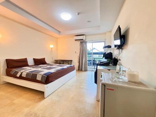 een slaapkamer met een bed en een televisie. bij Jommalai Boutique Hotel in Ban Nong Chaeng
