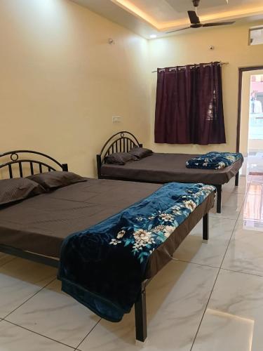 two beds sitting in a room with at KeshavShree home stay in Ujjain