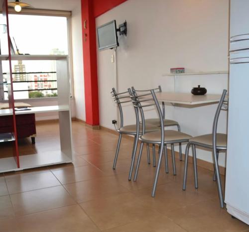 een eetkamer met stoelen, een tafel en een raam bij Monoambiente en Miramar in Miramar