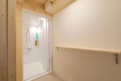 a bathroom with a shower and a glass door at SMA MO inn Chitose in Chitose