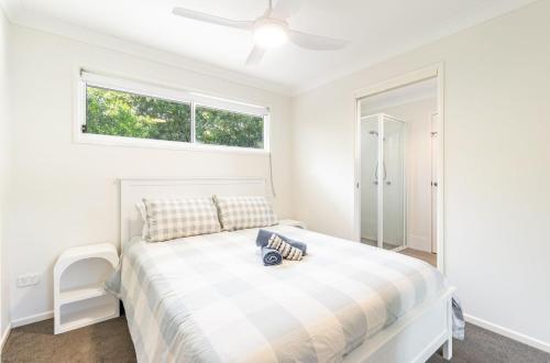 a white bedroom with a bed and a window at Iluka Sea Spray in Iluka