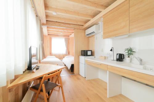 a kitchen with a counter and a desk in a room at SMA MO inn Omitama in Omitama