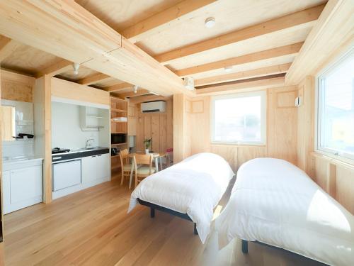 two beds in a room with a kitchen at SMA MO inn Omitama in Omitama