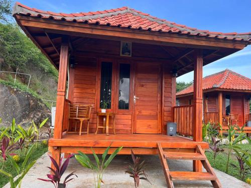 a wooden cabin with a porch and a ladder at The Mawun Lombok in Selong Belanak