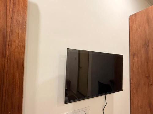 ein Flachbildfernseher, der an einer Wand hängt in der Unterkunft Port Inn Lodge in Mangaluru