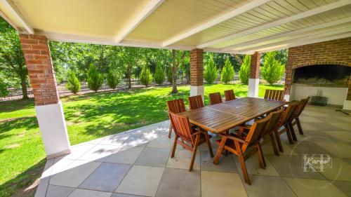 an outdoor patio with a wooden table and chairs at Die Karoo Patriot in Orania