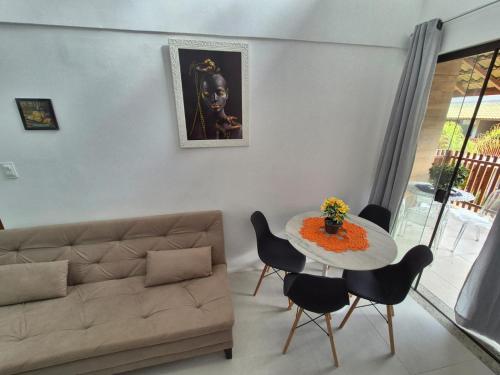 een woonkamer met een bank en een tafel met stoelen bij Condomínio Residencial Tiê in Camassari